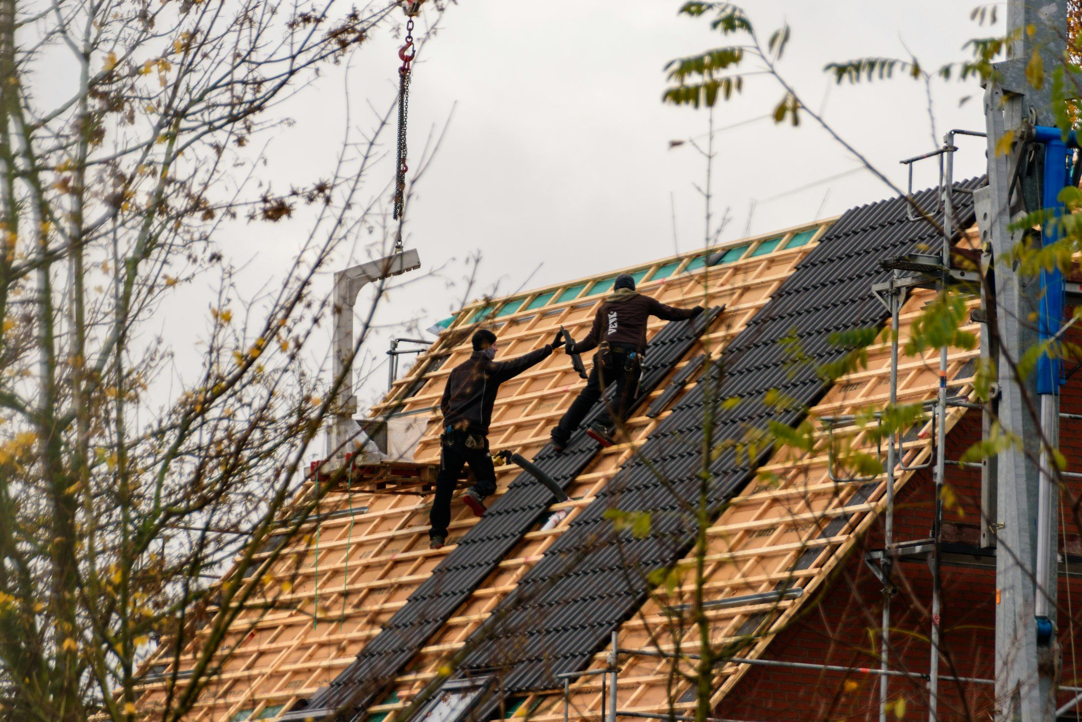 Roofers installing new roof tiles on battens A. Dawson Roofing Services Fife