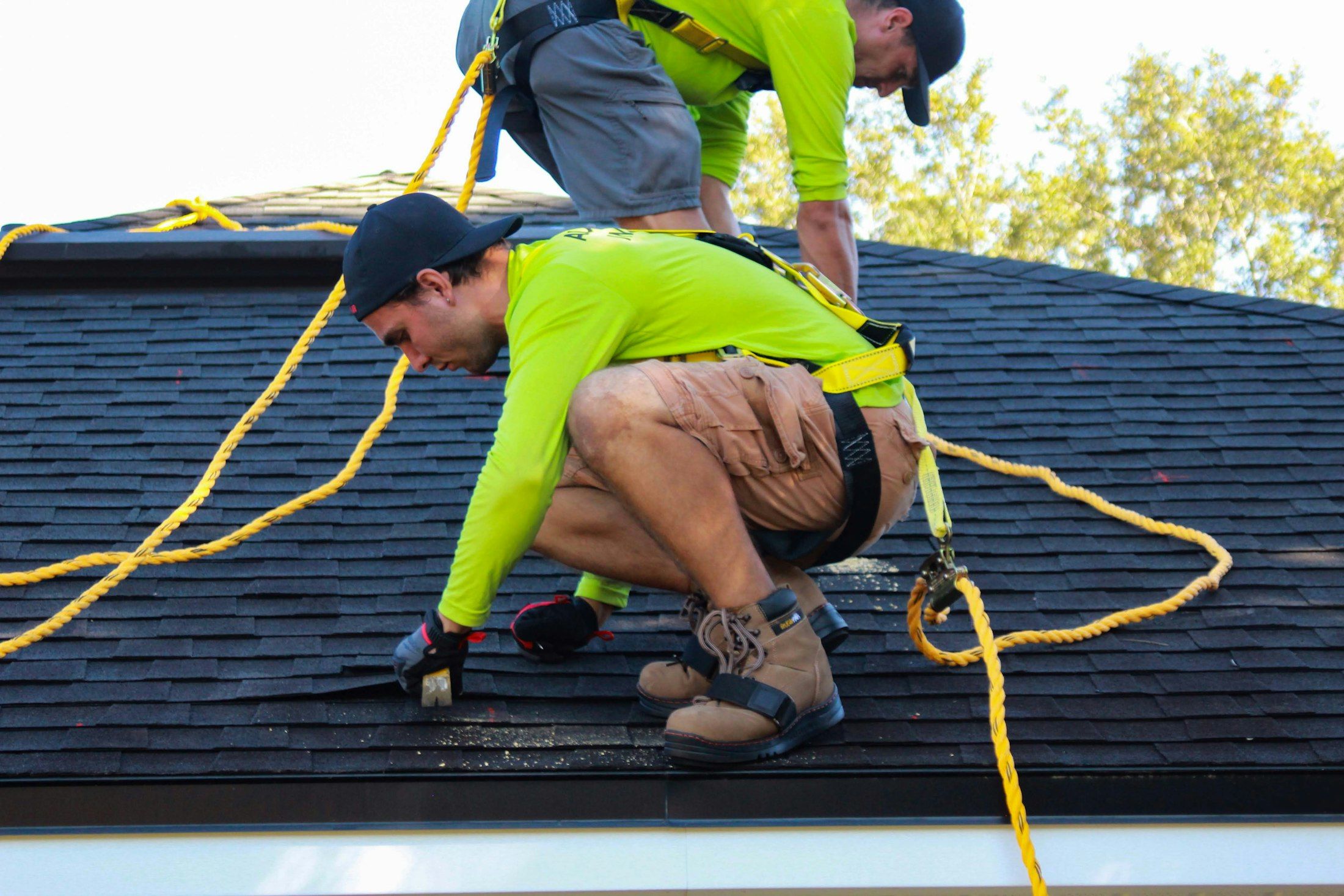 Two roofers carrying out roof repairs with safety harnesses A. Dawson Roofing Services Kirkcaldy